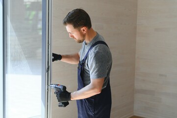 A worker installs windows in a new modular home. The concept of a new home.