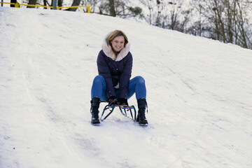 Adult woman riding on a sledge