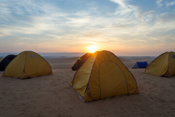 "Sunrise Over Safari Tents in the Desert: A Magical Moment of Tranquility and Beauty"