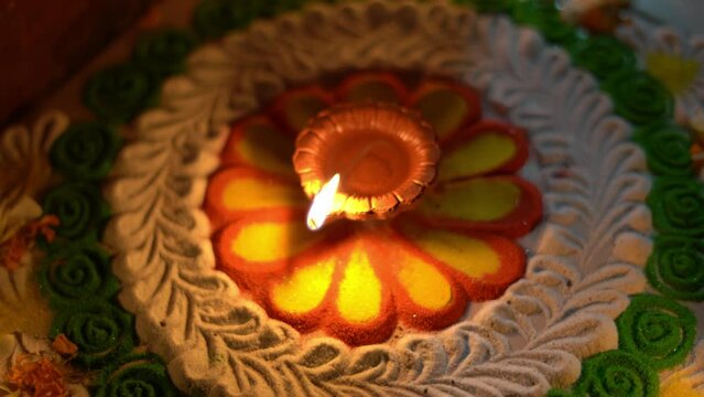 Diwali Diya or oil lamp lit on colourful rangoli. closeup shot of Diwali Diya 