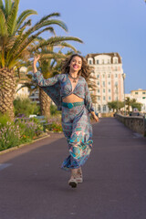 Obraz premium Smiling woman walking happily in the street in summer
