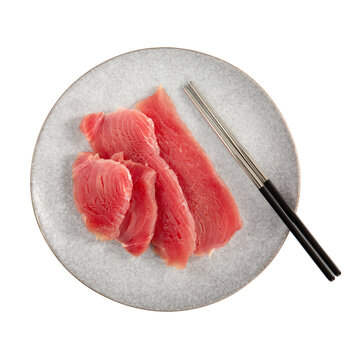 Slices of cold smoked tuna on gray plate isolated on white background. Top view.