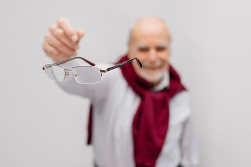 Vision correction and treatment. A mature man throws away his glasses after vision treatment. A...