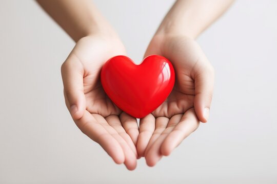 Hands of two people holding a red heart on the white background, in the style of lilia alvarado with AI