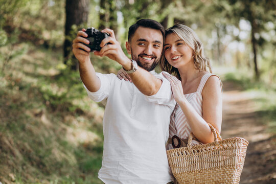 Young couple making photos in the forest