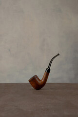 Smoking pipe on dark background. Wooden classic tabacco pipe.