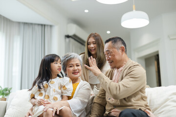 Happy Family Grandfather Grandmother and Granddaughter having fun living room at home. connects relationships different ages. Relax Time children with parents, Family Happiness Concept.