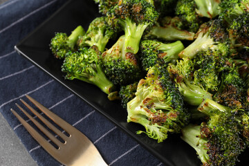 Tasty fried broccoli and fork on table, closeup
