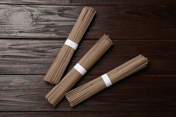 Uncooked buckwheat noodles (soba) on wooden table, flat lay