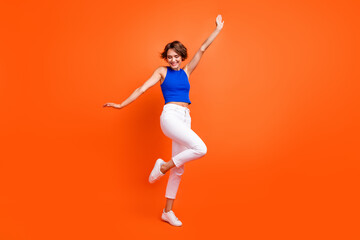 Fototapeta na wymiar Full size photo of gorgeous lovely girl have good mood dancing rejoice isolated on vivid orange color background