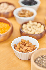 bowl with delicious almonds near plant-based food on blurred background, vegetarian nutrition