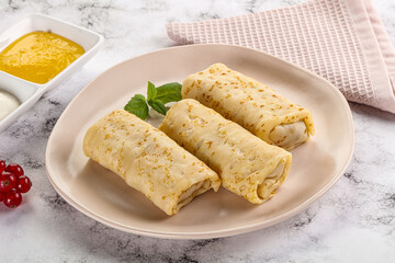 Homemade stuffed pancakes with honey and cream sour
