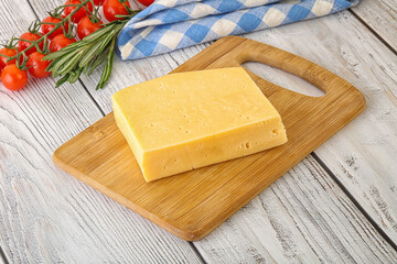 Piece of natural organic cheese over board