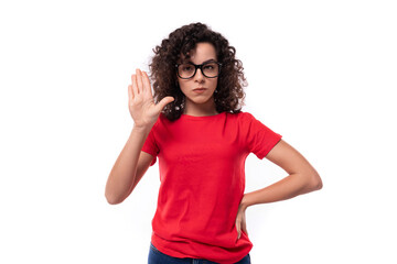 a young well-groomed woman in glasses for vision is dressed in a red basic T-shirt actively gesturing pointing with her hands