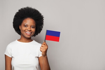 Haitian woman holding flag of Haiti Education, business, citizenship and patriotism concept - obrazy, fototapety, plakaty