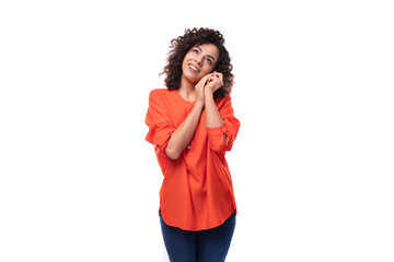 young dreamy caucasian business woman with wavy hair dressed in an orange blouse on a white background