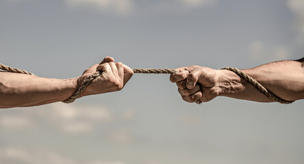 Conflict tug of war. Hand holding a rope, climbing rope, strength and determination. Rescue, help, helping gesture or hands - obrazy, fototapety, plakaty