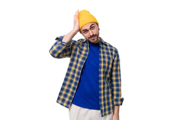 handsome smart young male hipster in cap and shirt thinking over white background with copy space