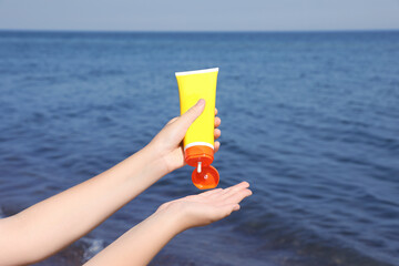 Woman applying sunscreen outdoors, closeup. Sun protection care