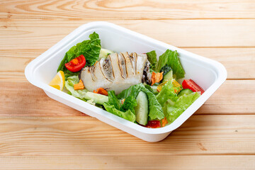 Squid stuffed with rice and mushrooms. Healthy diet. Takeaway food. Eco packaging. On a wooden background.