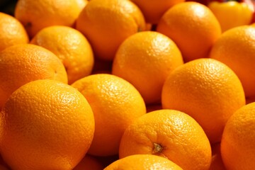 Heap of fresh oranges on counter at market, closeup