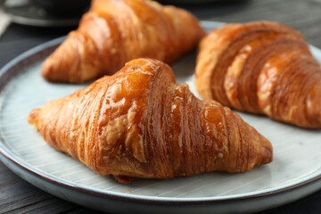 Delicious fresh croissants on dark table, closeup