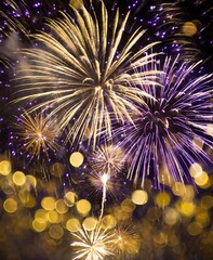 Gold and dark violet fireworks and bokeh in New Year eve and copy space. Abstract background holiday