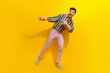 Fototapeta na wymiar Full body photo of man in vintage outfit direct fingers empty space enjoy spend money in old school bar isolated on yellow color background