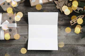 Fototapeta na wymiar Flat lay composition with blank paper sheet, gift boxes and Christmas decor on wooden table, space for text. Letter to Santa