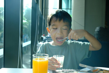 Little asian boy enjoying breakfast food in luxury hotel