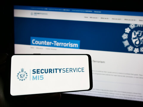 Stuttgart, Germany - 11-11-2023: Person holding cellphone with logo of British counter-intelligence agency Security Service (MI5) in front of webpage. Focus on phone display.