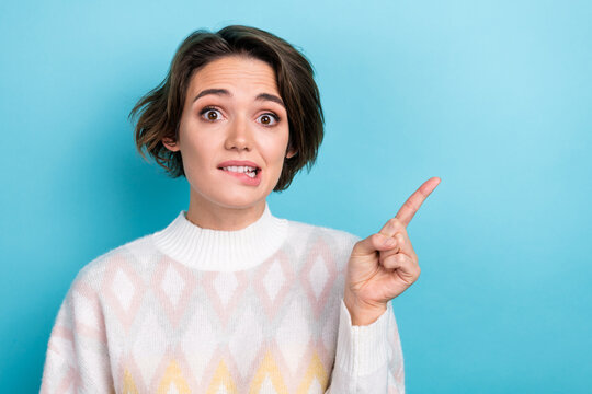 Photo of nervous girl panic which dress should buy first biting lips direct finger empty space boutique isolated on blue color background