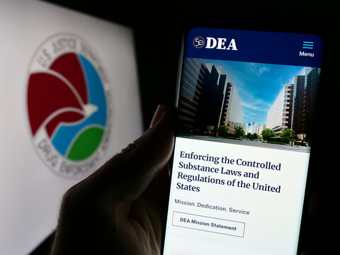 Stuttgart, Germany - 11-11-2023: Person holding mobile phone with website of United States Drug Enforcement Administration (DEA) with seal. Focus on center of phone display.