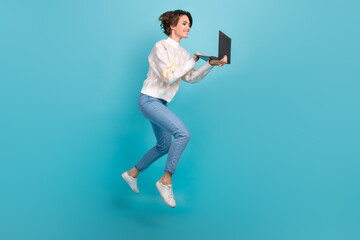 Fototapeta na wymiar Full body length photo of jump running project manager young lady wear pullover denim jeans remote worker isolated on blue color background
