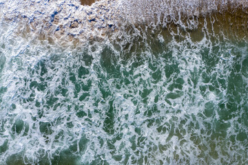 Aerial view of wild sea waves crushing the beach