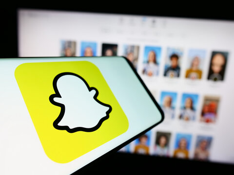Stuttgart, Germany - 11-14-2023: Mobile phone with logo of American multimedia instant messaging app Snapchat in front of website. Focus on center-left of phone display.