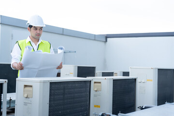 Asian maintenance engineer works on the roof of factory. contractor inspect compressor system and...