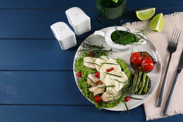 Delicious mozzarella, chicken and vegetables with tarragon served on blue wooden table, above view....