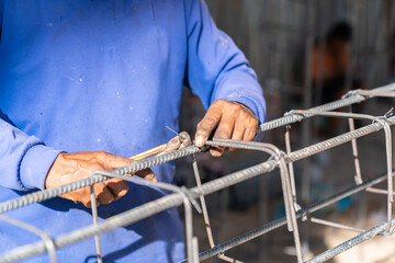 Worker bundle wire steel rod for construction job.