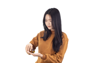 A Asian young woman pours out medicine into her hand isolated on white background with clipping path.