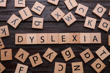 Squares with word Dyslexia on wooden background, flat lay