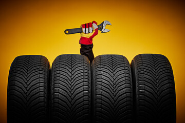 Winter car tires and hand of mechanic with wrench, screwdriver, automobile services.