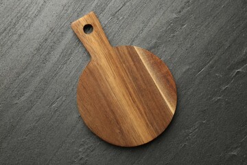 One wooden cutting board on dark grey table, top view