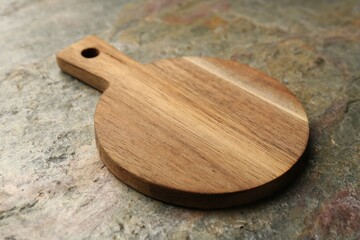 Wooden cutting board on textured table, closeup