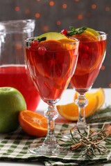 Christmas Sangria cocktail in glasses and ingredients on table