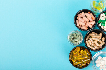 Vitamins and supplements. Variety of vitamin tablets on a textured background. Multivitamins with fresh and healthy fruits. Nutritional supplements. Flat layout. Place for text. Copy space