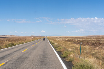Motorcycle on the open road in the desert on a bright blue day
