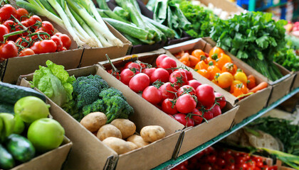 fresh vegetables in cardboard boxes on market