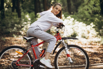Young sporty woman riding bicycle in the park