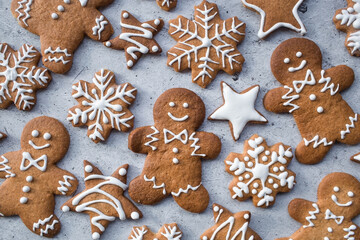 Homemade gingerbread Christmas cookies in icing sugar. Delicious gingerbread cookies on the background of a bokeh of Christmas tree lights. Freshly baked Christmas gingerbread cookies.
